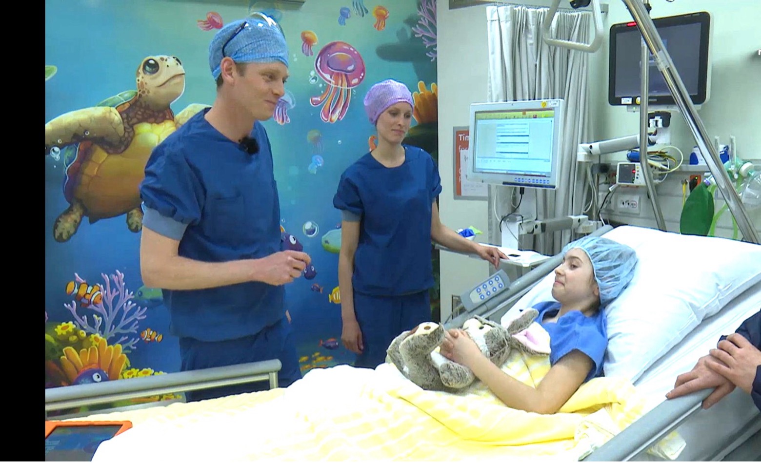 A child calmly interacting with technology in a pediatric hospital bed.
