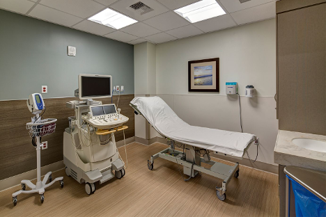 A standard pediatric examination room with clinical equipment.